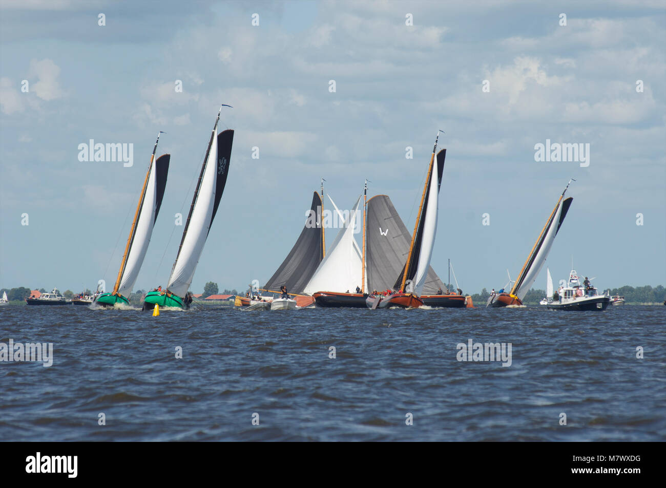 A traditional sailing race with classic Dutch wooden flat-bottemend boats on the lakes in Frisia, The Netherlands Stock Photo