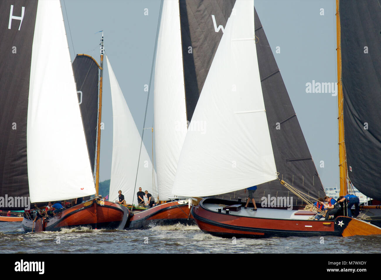 A traditional sailing race called skutsjesilen with classic Dutch wooden flat-bottemend boats on the lakes in Frisia, The Netherlands Stock Photo