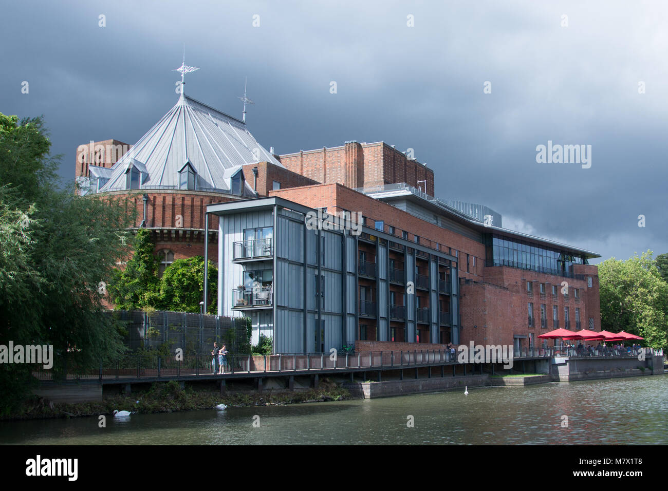 view of the RSC Royal Shakespeare Theatre Stratford upon Avon from the river with dark stormy clouds in the background. Stock Photo