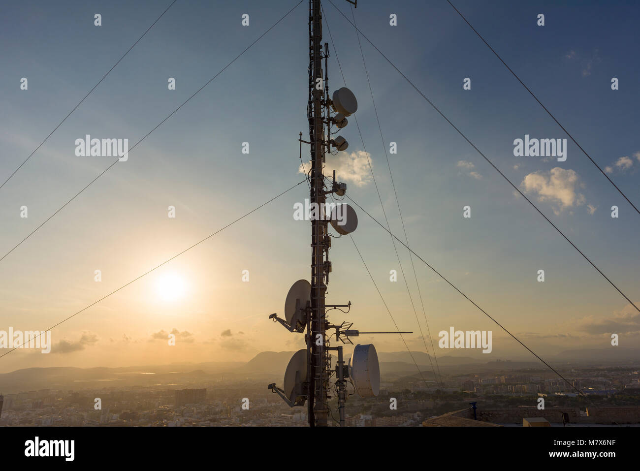 The radio transmission tower at Santa Barbara Castle on Mount Benacantil at sunset overlooking Alicante City, Spain Stock Photo