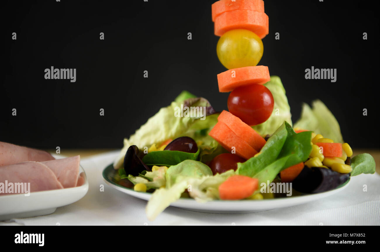 creative fresh green leaf salad with ham lettuce tomatoes and carrot Stock Photo