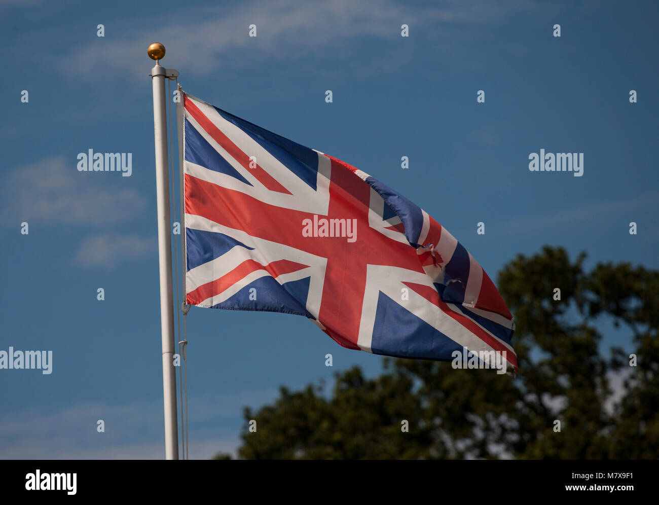 Union Jack Flag blowing in the wind against a sunny blue sky Stock ...