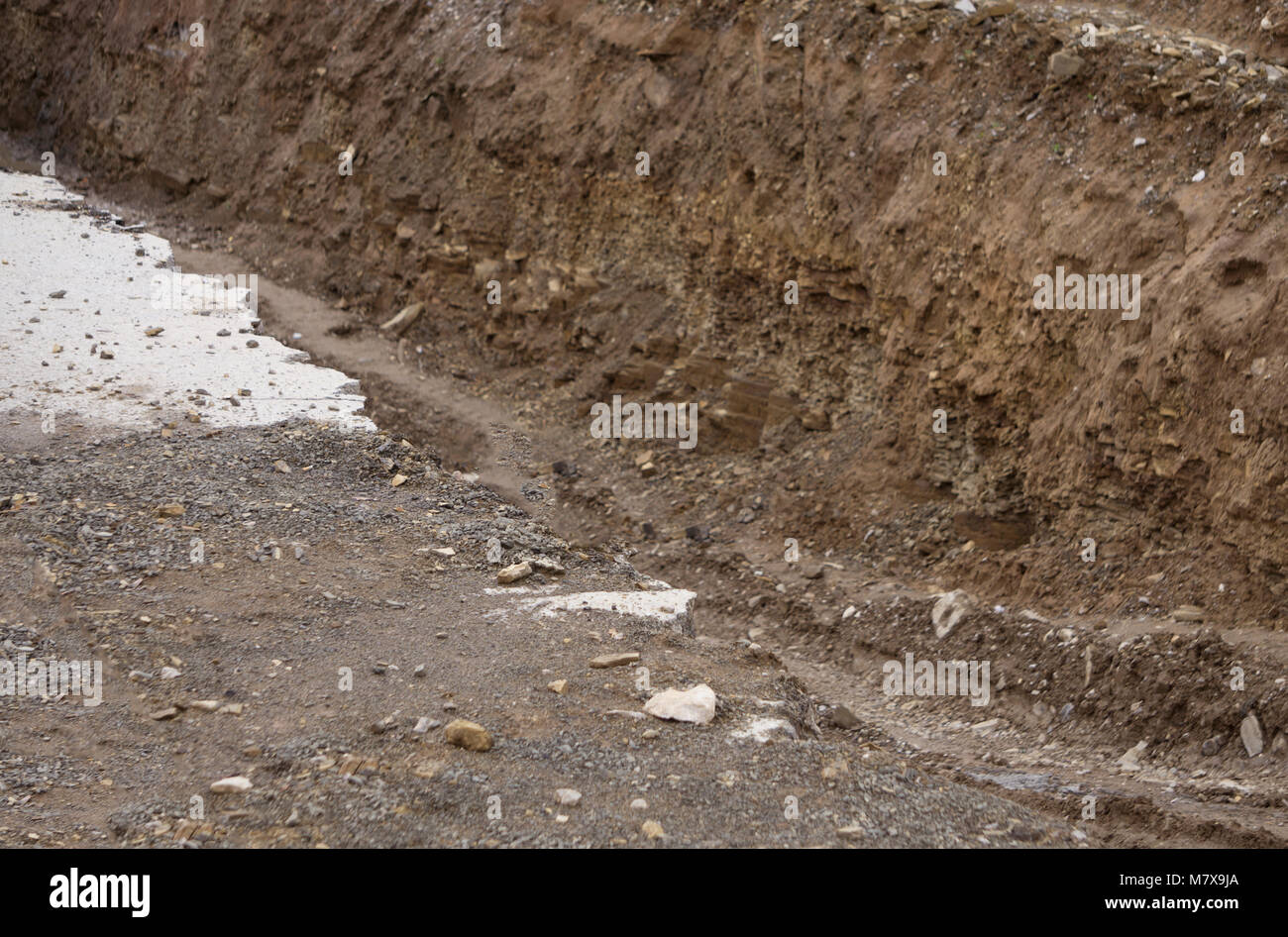 Side of the broken asphalt road collapsed and fallen, since the ground collapsing. Stock Photo