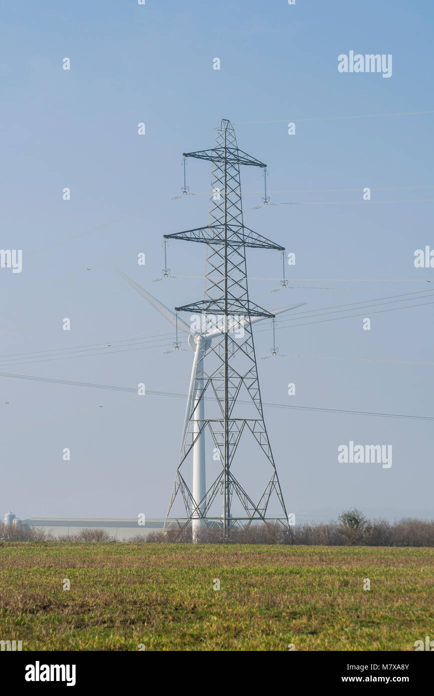 Wind turbine and electricity pylon in a rural area Stock Photo