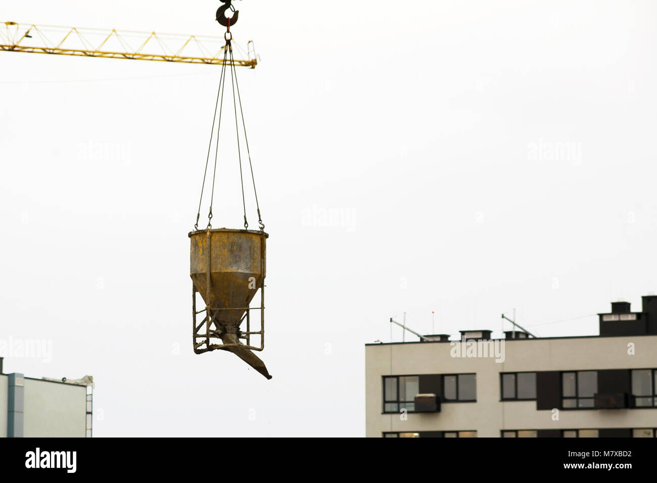 Lifting concrete bucket up by crane hi-res stock photography and images
