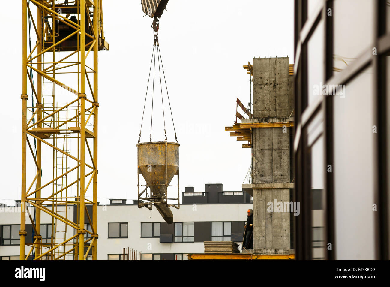 Lifting concrete bucket up by crane hi-res stock photography and images