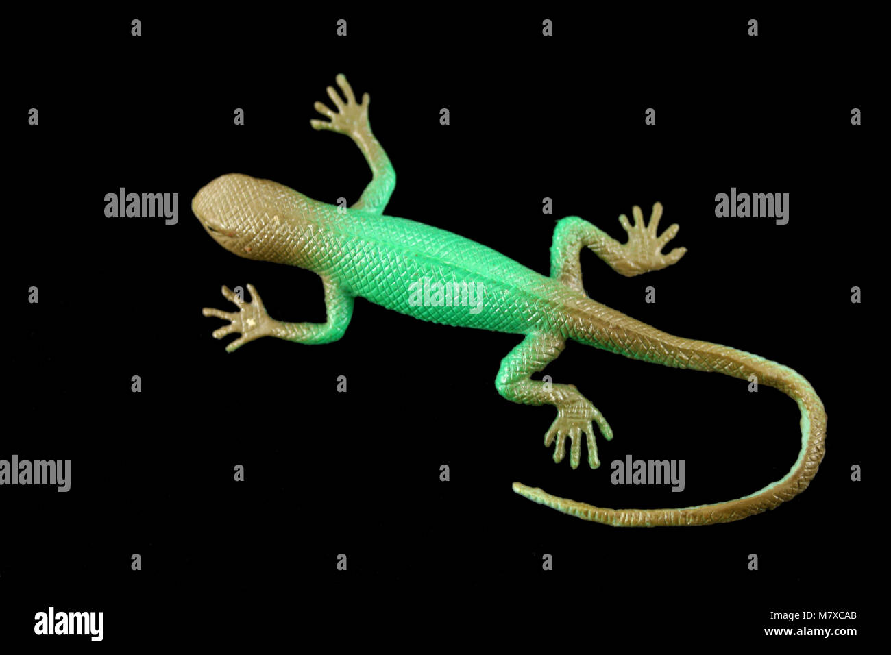 A Green plastic lizard isolated on black Stock Photo Alamy