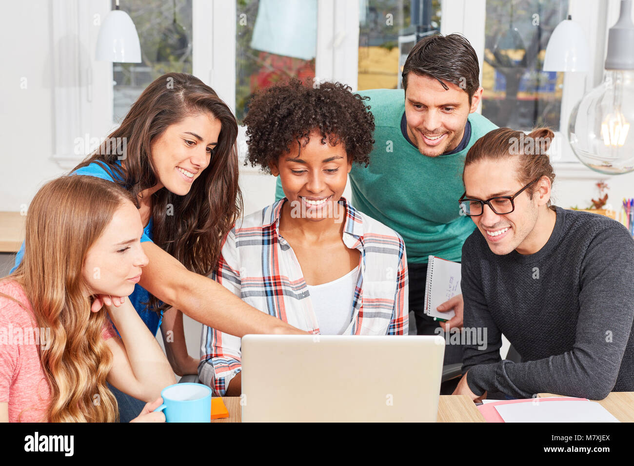 Group of students in business start-up analyzing an idea on a laptop Stock Photo