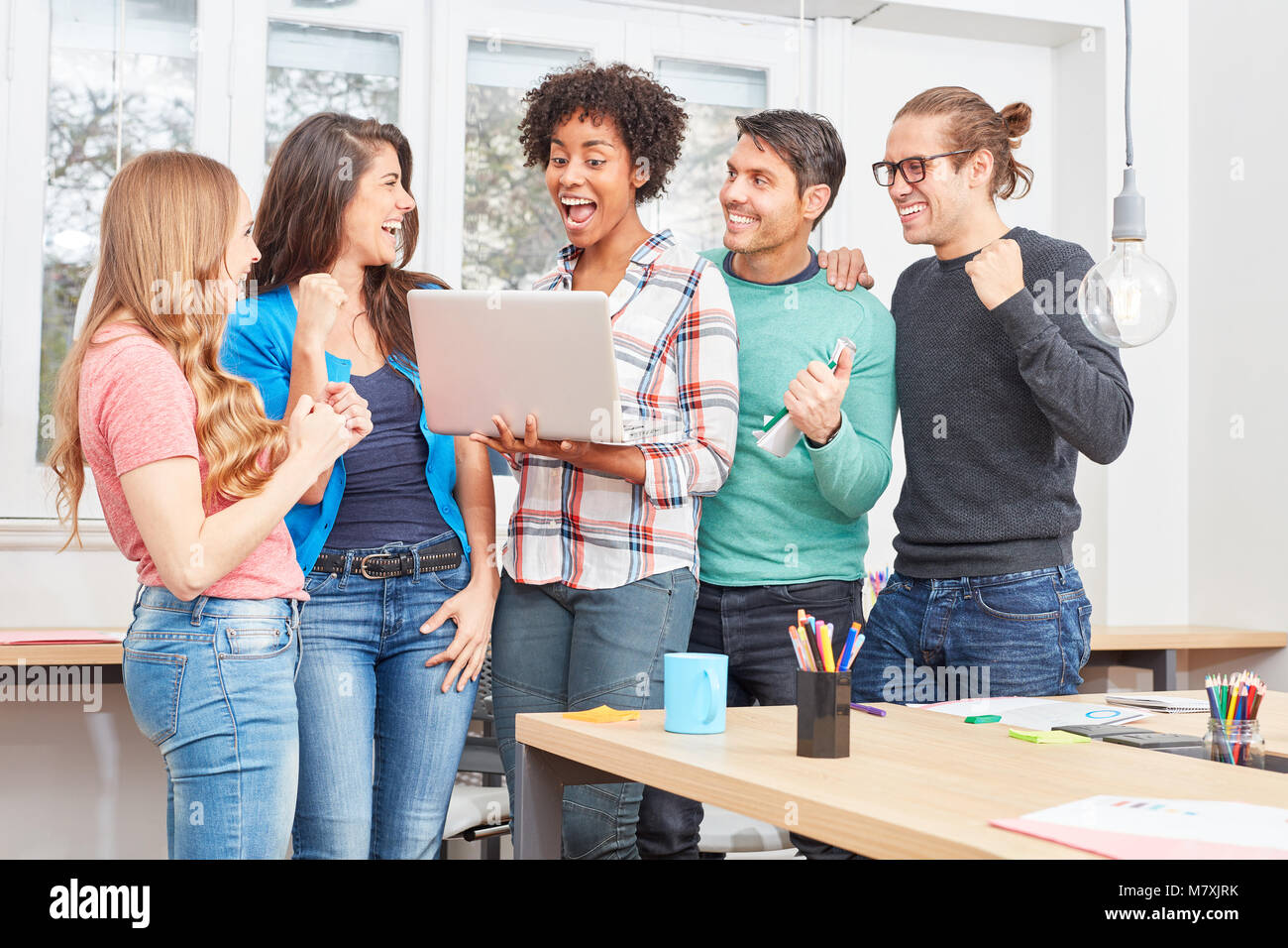 Young start-up team is excited about an innovation on the laptop PC Stock Photo