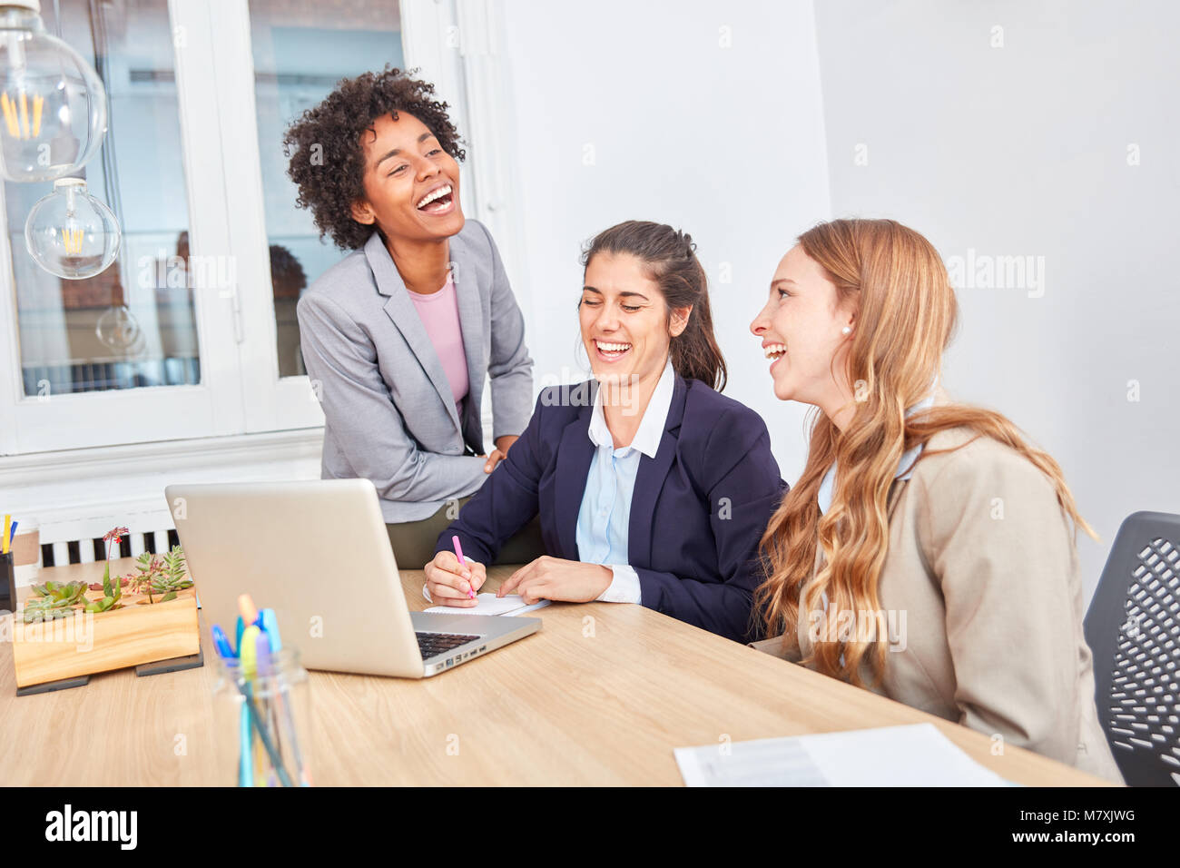 Young business women as a team have fun at laptop computer in start-up ...