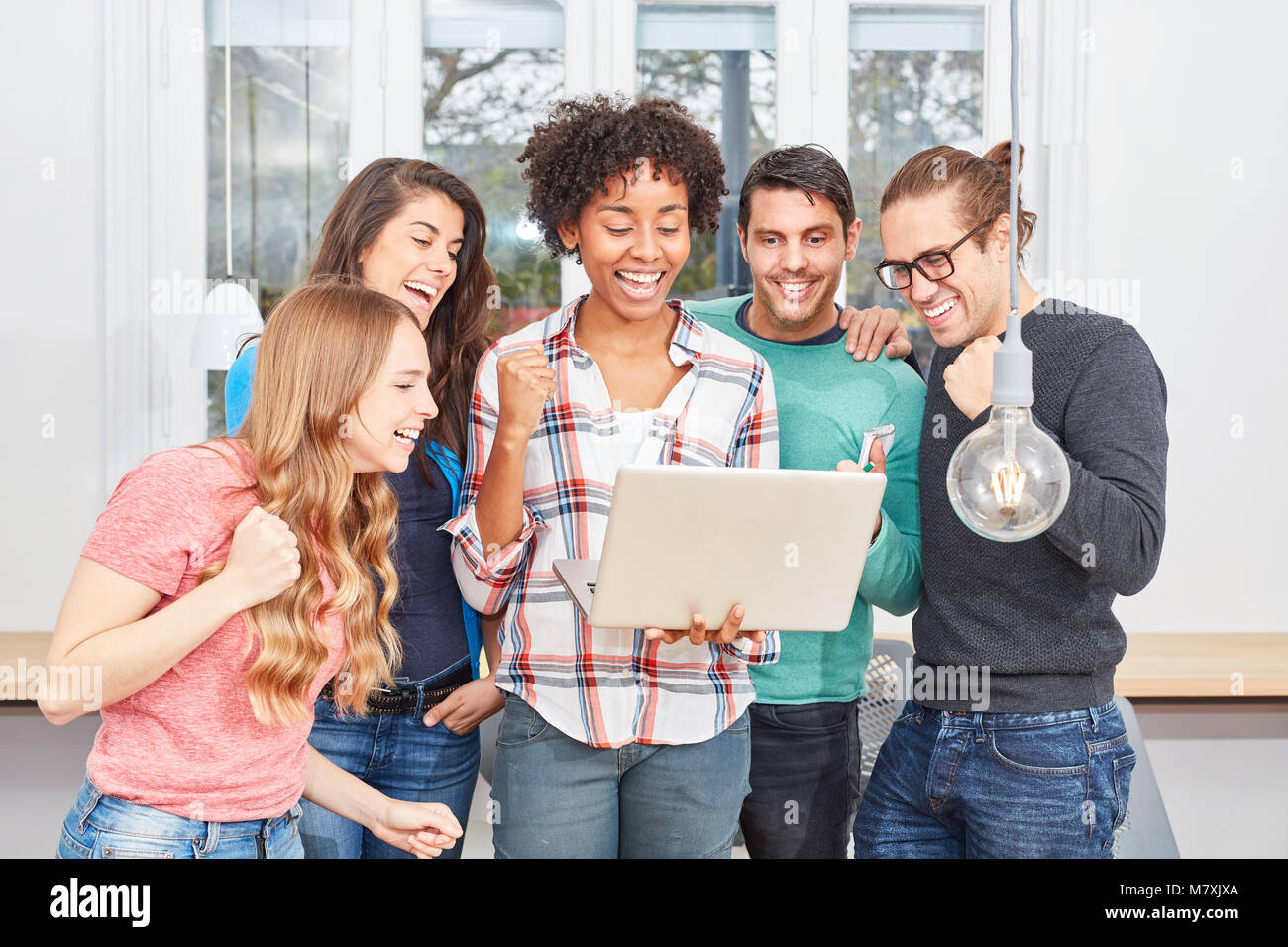 Internet start-up team cheers about good news on laptop computer Stock Photo