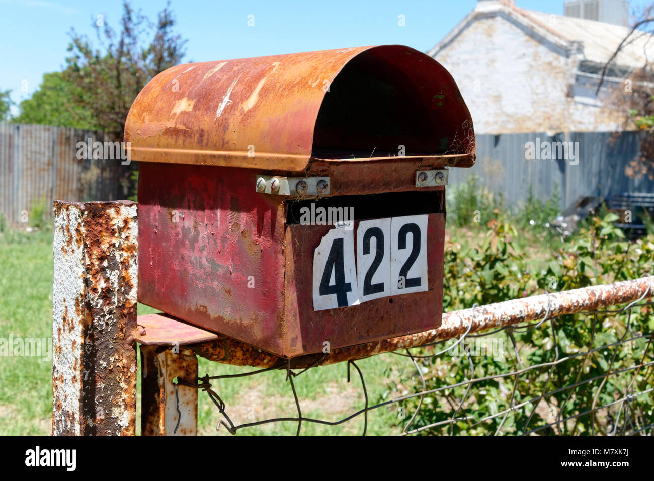 Old metal letterbox on fence, Hay, New South Wales, Australia. Stock Photo
