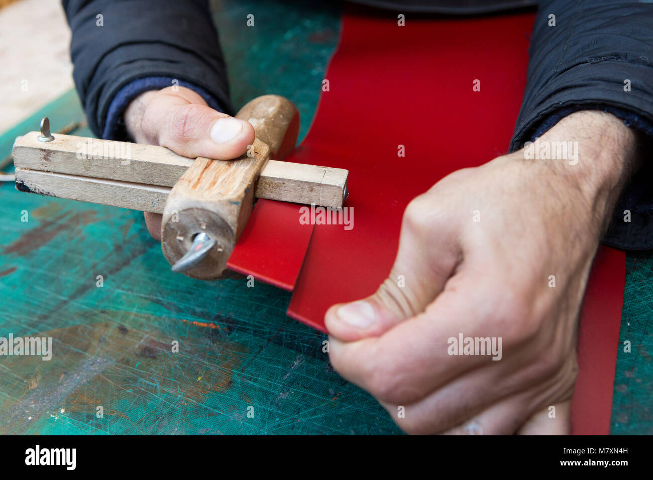 Artisan leather worker making a belt. Stock Photo