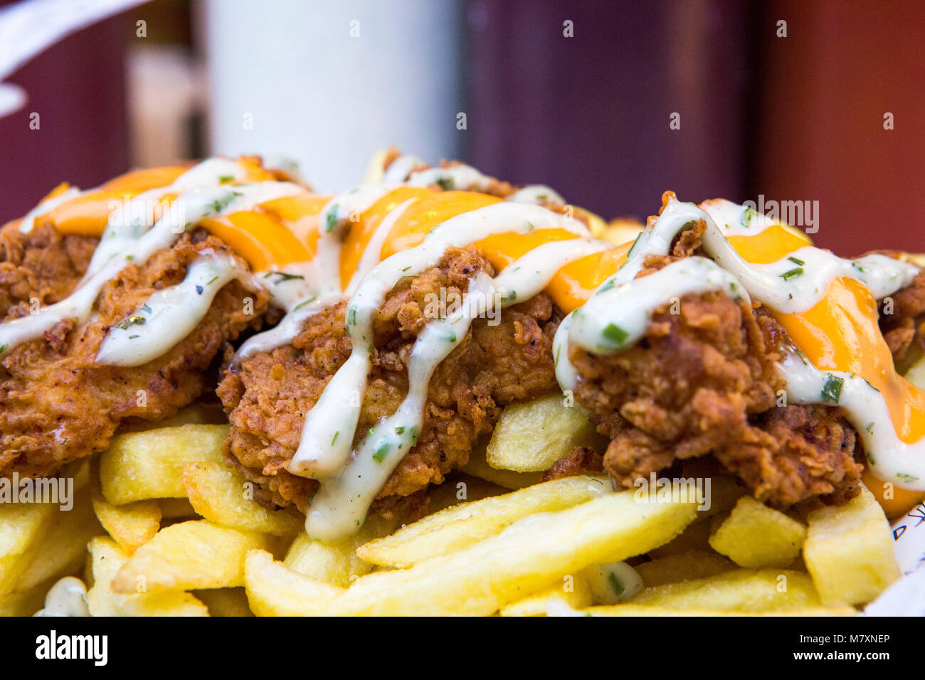 Fried chicken and chips with cheese. Stock Photo