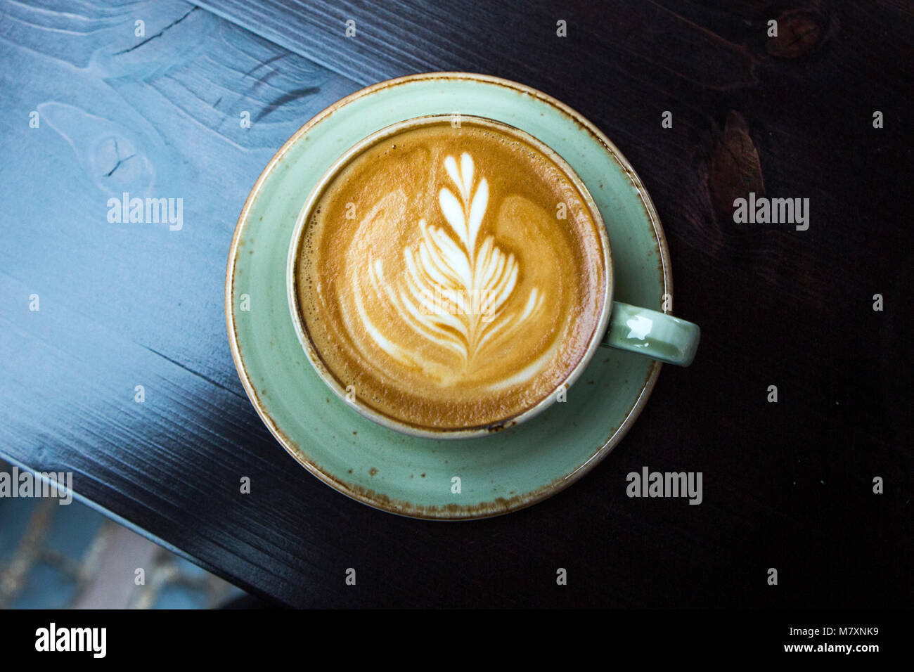 Cappuccino in green coffee cup and saucer. Stock Photo