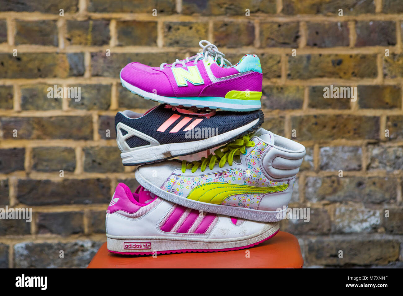Pile of vintage trainers held by a woman. Stock Photo