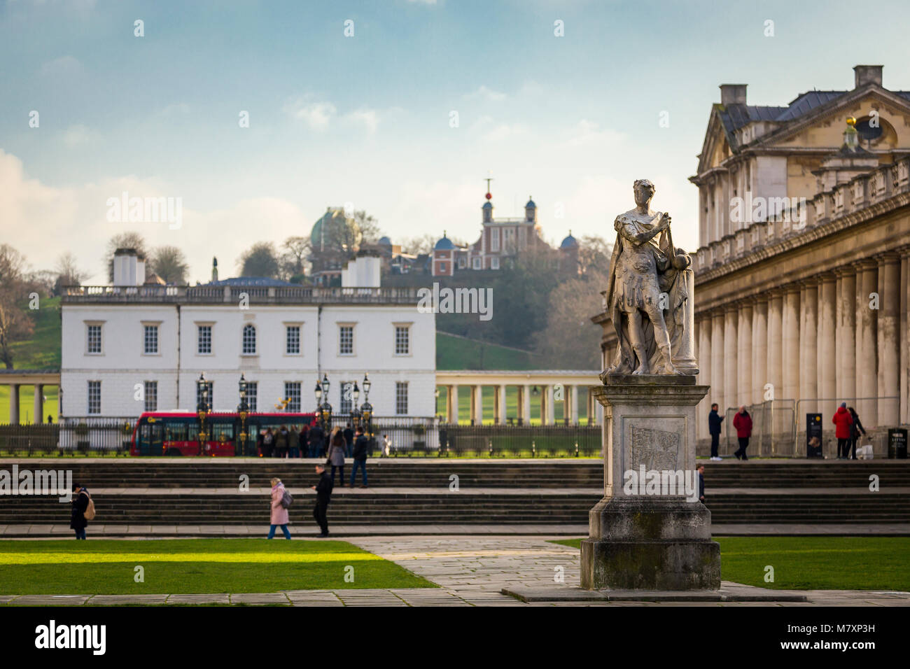 LONDON, UK – JAN 2018:  The Queen's House in Greenwich with Royal Observatory in background and students of Greenwich University walking past  statue  Stock Photo