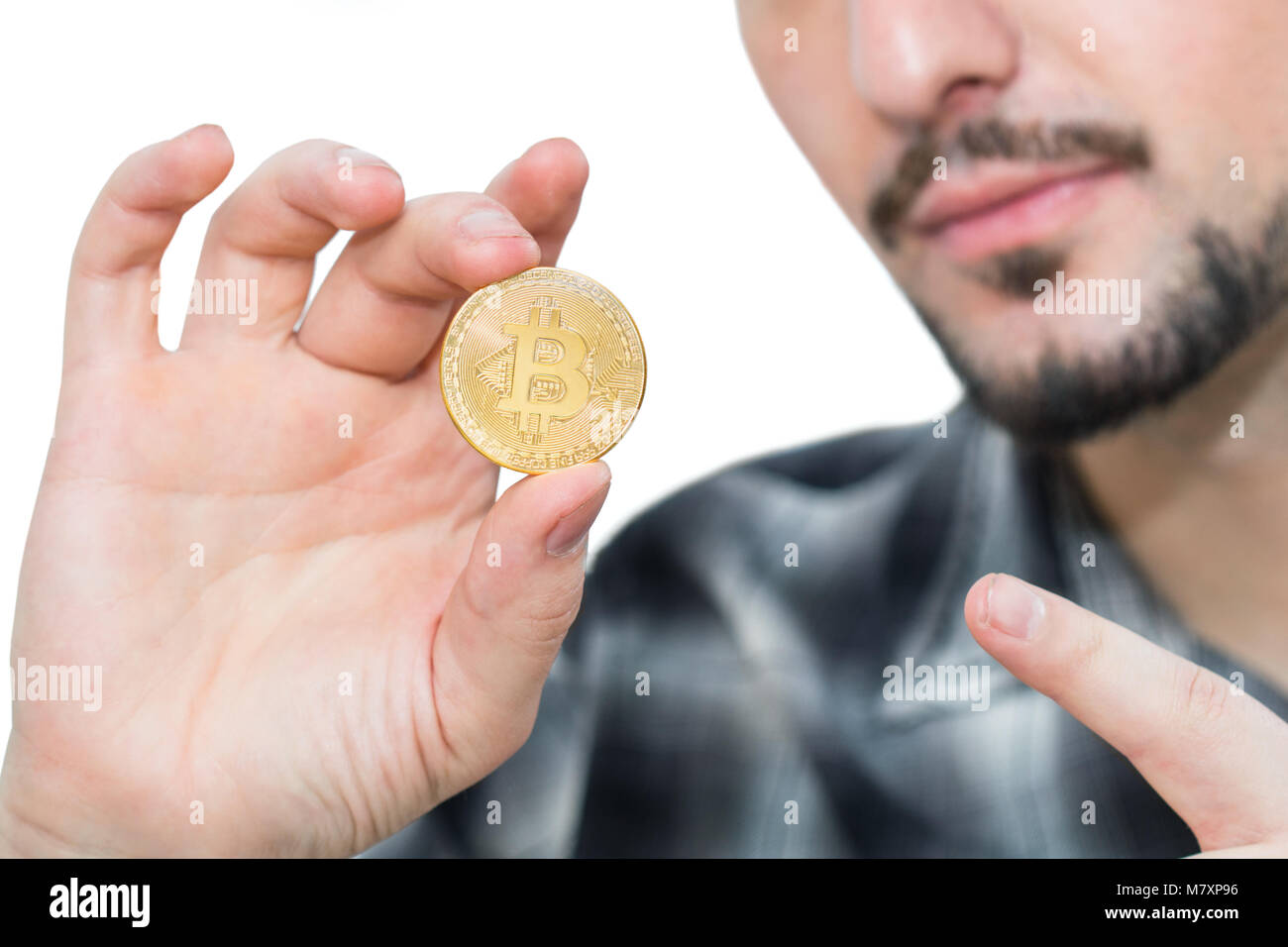 Modern bearded man holding a bitcoin, new cryptocurrency money in his hand  and pointing a finger at it Stock Photo - Alamy