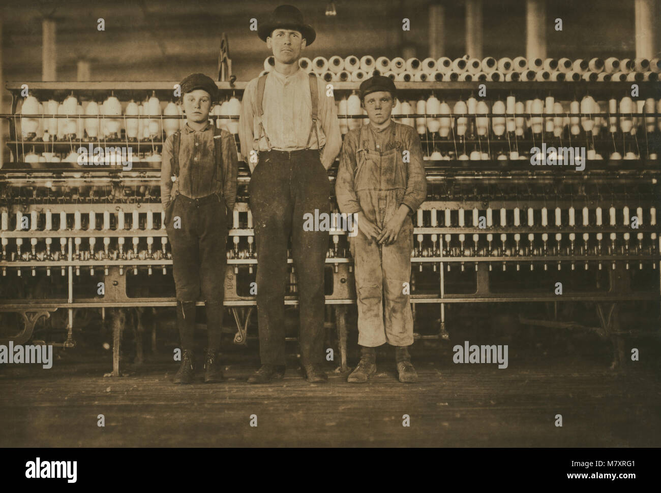 Overseer and Two Doffer Boys, Full-length Portrait, Avondale Cotton Mills, Birmingham, Alabama, USA, Lewis Hine for National Child Labor Committee, November 1910 Stock Photo