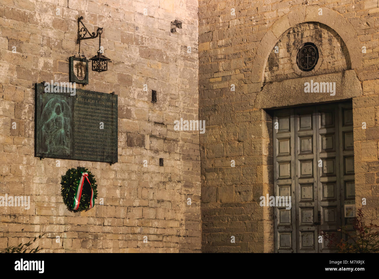 gateway to the Basilica of St. James in Bellagio, Italy where on a plaque is written in Italian - in memory of his glorious missing MCMXV XVIII St. Ja Stock Photo