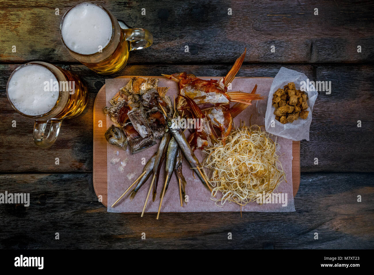 Assorted beer snacks with beer mugs Stock Photo