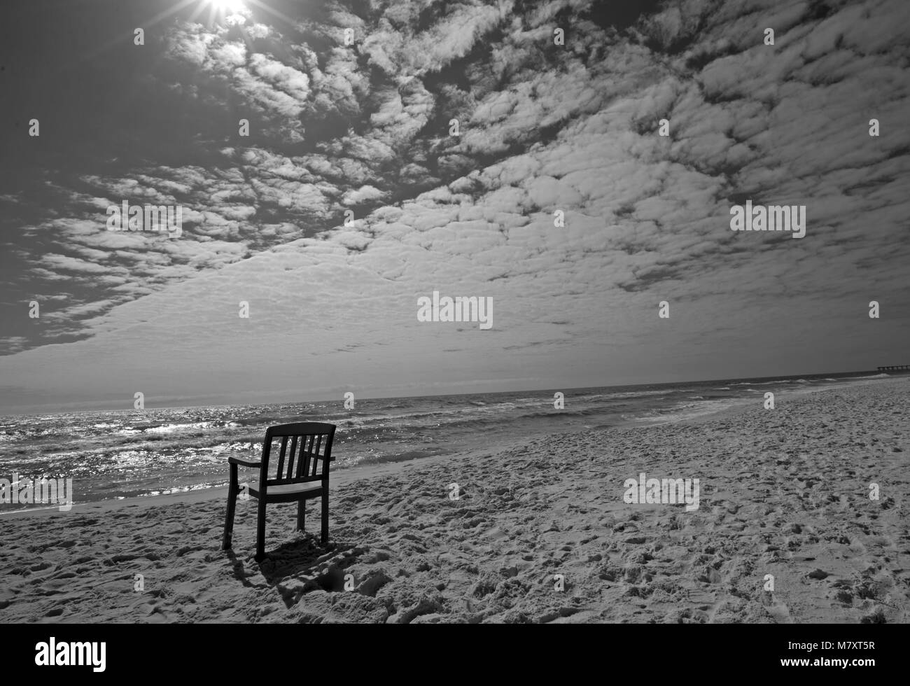 Black and white photograph of my lone chair on Panama City Beach on a cloudy day. Stock Photo