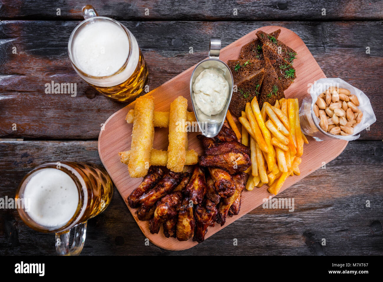 Assorted beer snacks with beer mugs Stock Photo