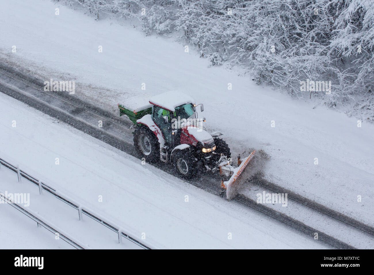 A tractor clearing snow from a dual carriageway in Redditch, Worcestershire, UK Stock Photo