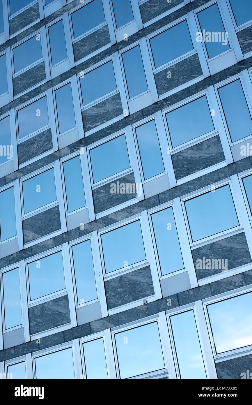 Blue sky reflected in glass windows of a building Stock Photo