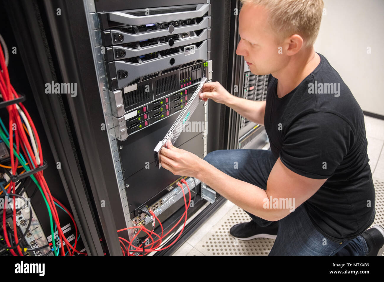 Engineer Checking Computer Server In Datacenter Stock Photo