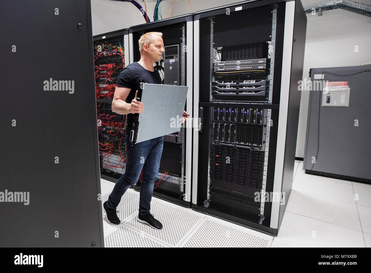 Computer Engineer Carrying Blade Server While Walking In Datacen Stock Photo