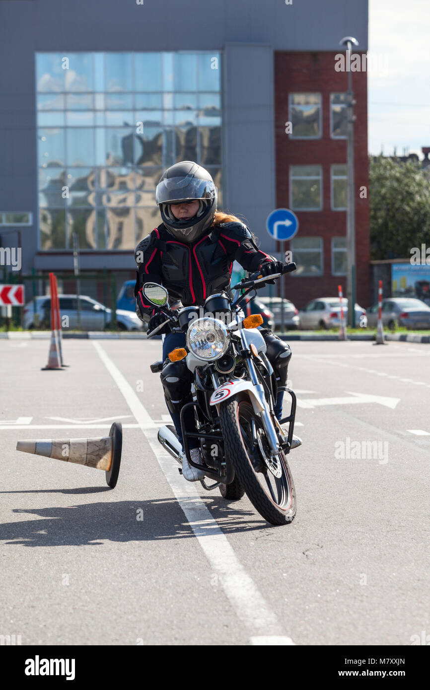 L-driver motorcyclist doing exercises with cones on asphalt ground Stock Photo