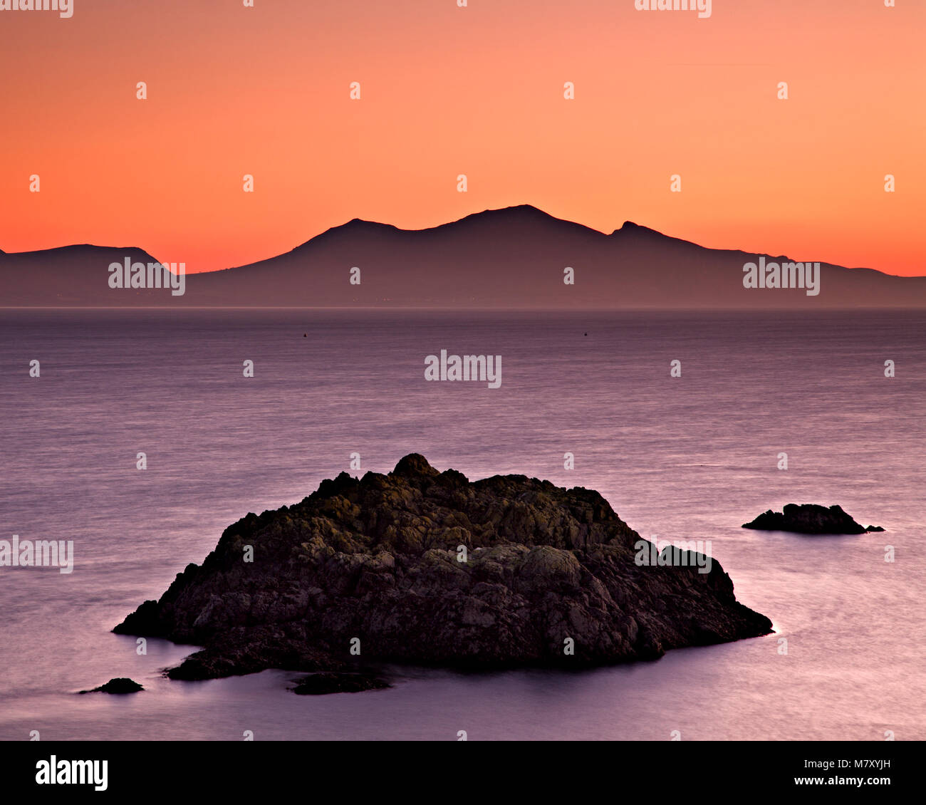 Rocks in the sea of Llanddwyn Island, Anglesey, North Wales at dusk Stock Photo