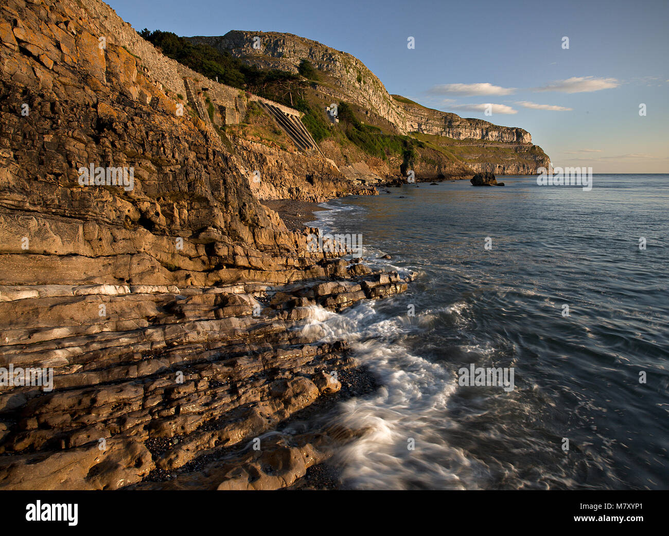 Waves breaking at the foot of the Great Orme, Llandudno, North Wales coast at sunrise Stock Photo
