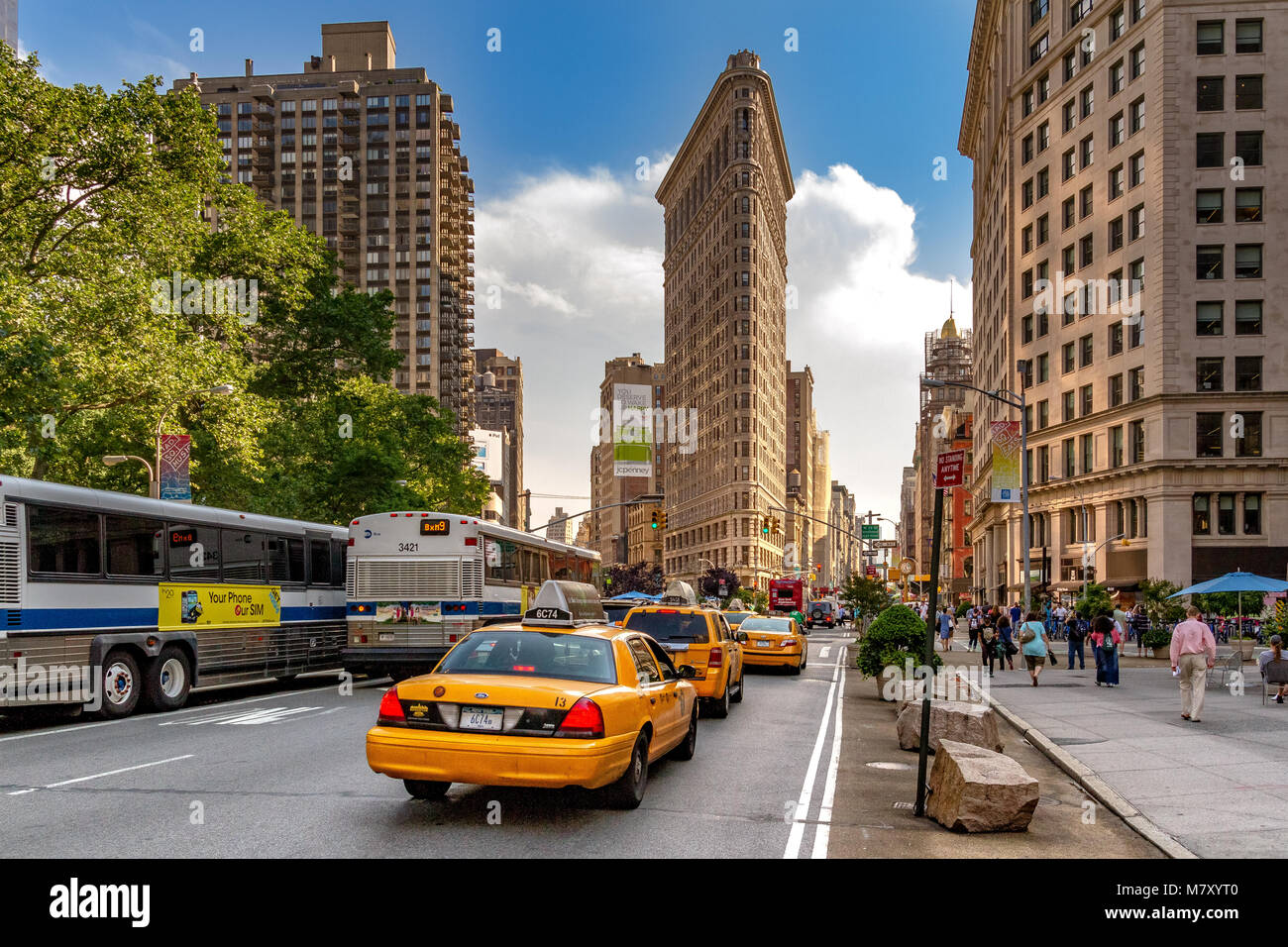 Yellow New York taxis approaching the The Flat Iron Building on 5th Avenue , Manhattan , New York City Stock Photo