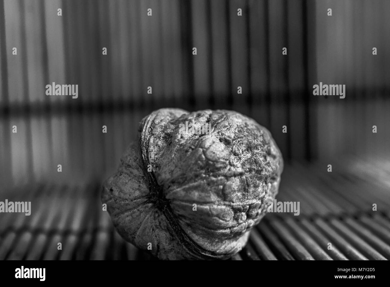 Monochrome Walnut lie on a wooden bamboo table, background for web site or mobile devices. Stock Photo