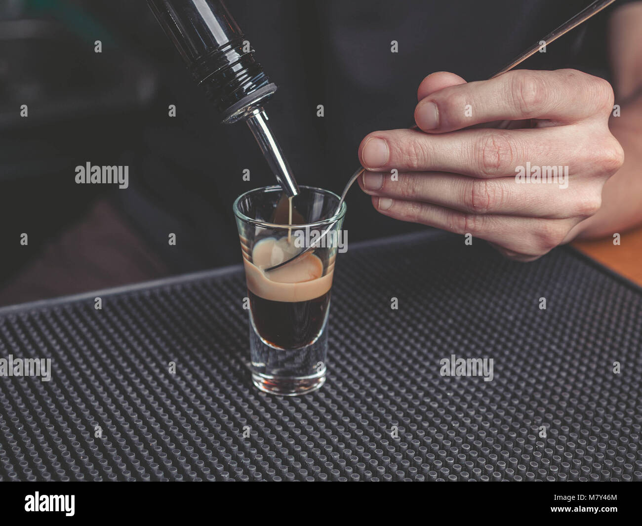 The bartender prepares a B-52 cocktail at the bar Stock Photo