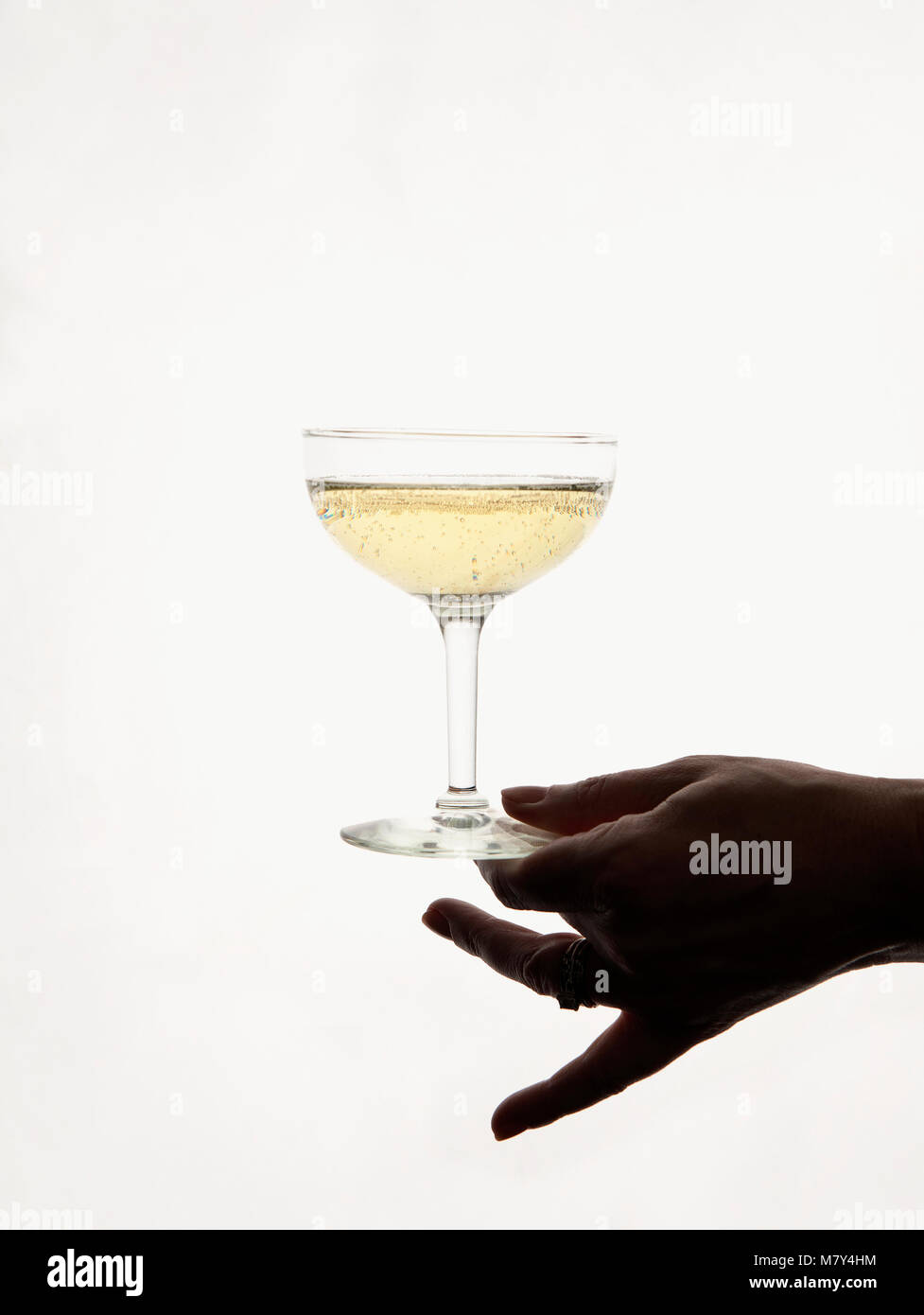 A hand holding a glass of champagne. Stock Photo