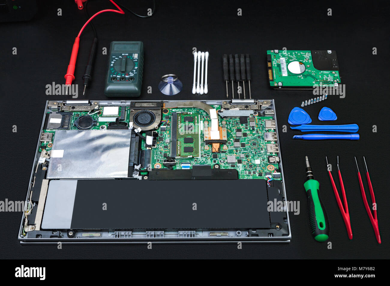 Disassembled Laptop With Computer Parts And Special Tools For
