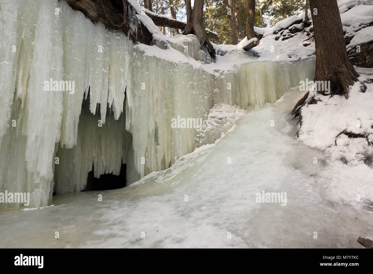 Eben Ice Caves in Michigan's Upper Peninsula spill over a rock ledge, like a waterfall, creating patterned ice curtains, near Eben Junction Michigan. Stock Photo
