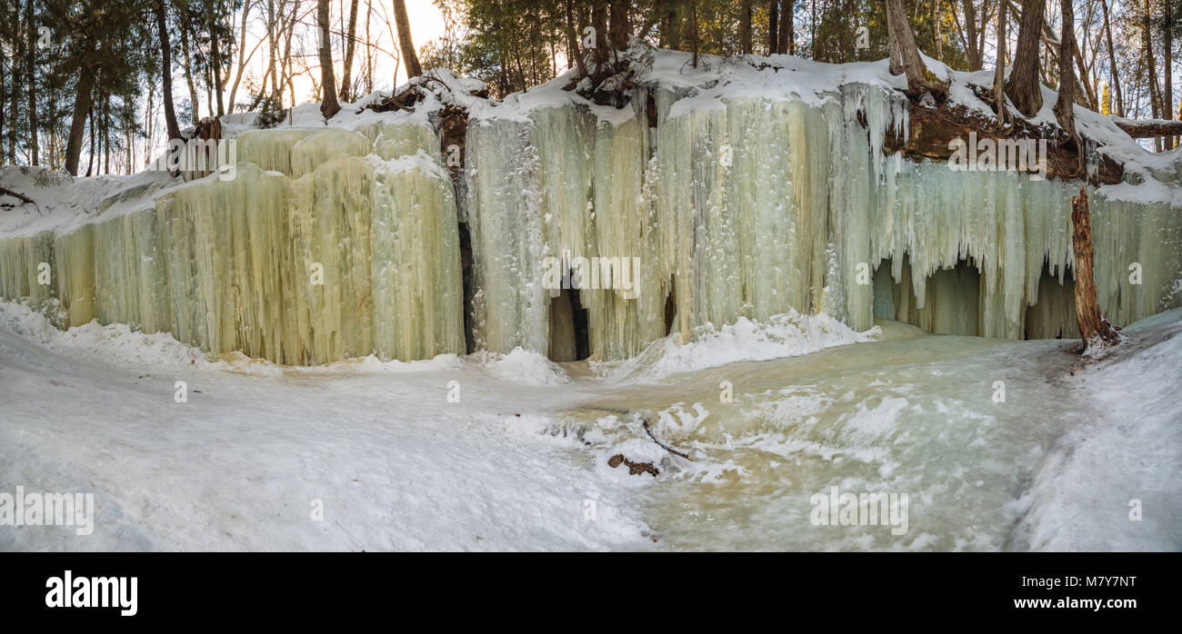 Eben Ice Caves in Michigan's Upper Peninsula spill over a rock ledge, like a waterfall, creating patterned ice curtains, near Eben Junction Michigan. Stock Photo