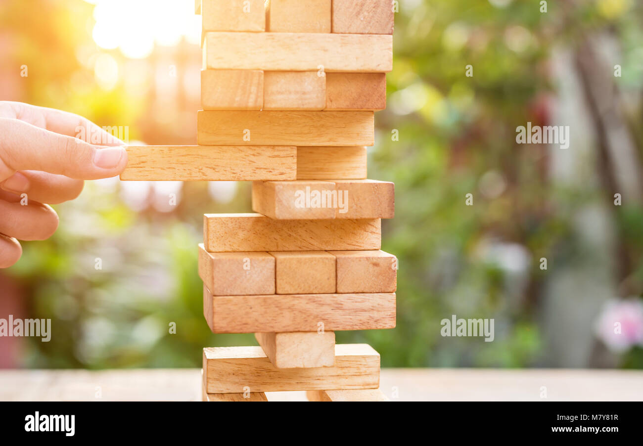 Close up hand holding blocks wood game on blurred green background. With copy space for text or design concept Stock Photo