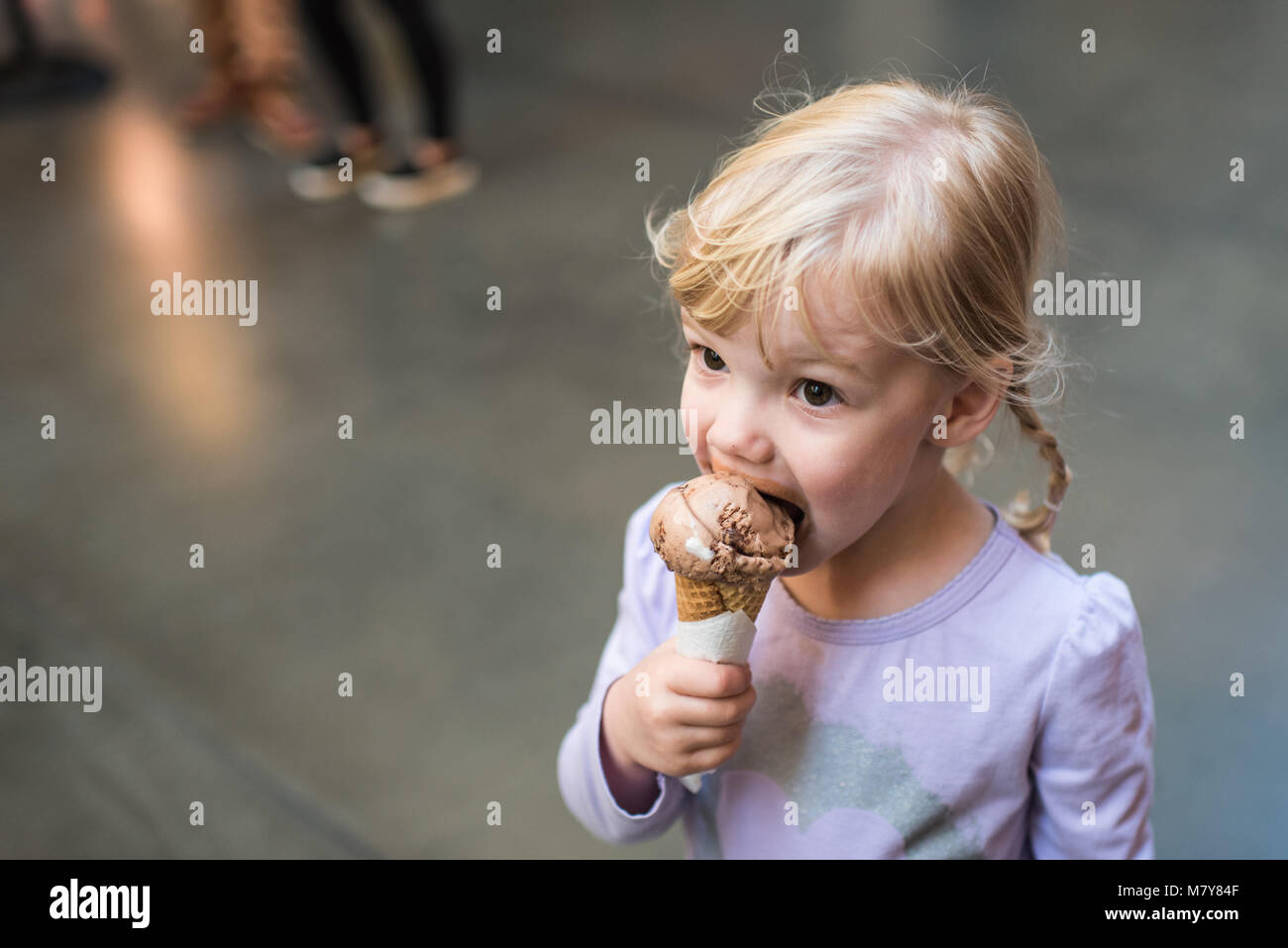 child eating ice cream cone in marketplace Stock Photo