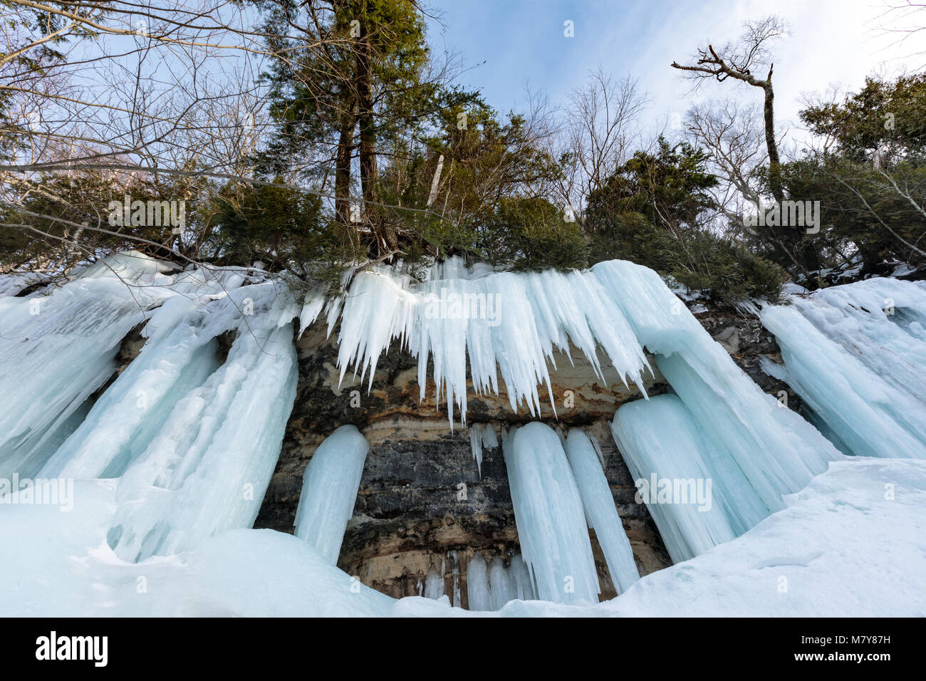 Ice caves and ice curtains form along the Pictured Rocks escarpment on Sand Point Road in Munising Michigan. These ice curtains are popular for ice cl Stock Photo