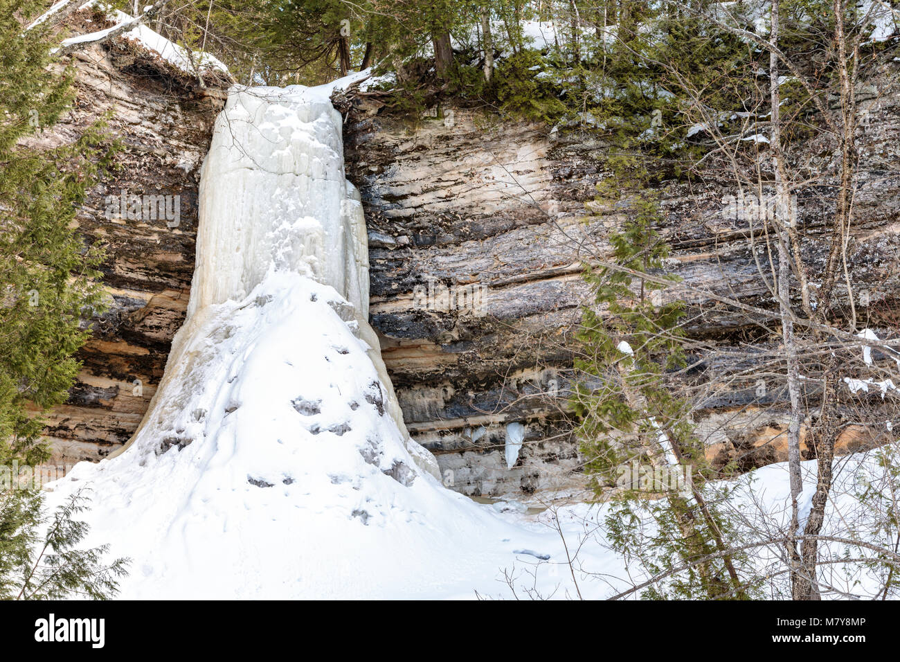 Munising Falls, a waterfall in Munising Michigan freezes solid in winter time, surrounded by basalt and sandstone rock. Stock Photo
