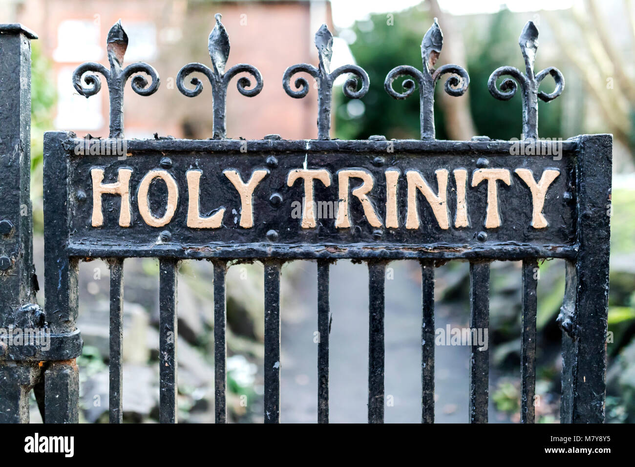 Old wrought iron Holy Trinity Rectory Gates with peeling paint and cobwebs in a church yard or cemetary in England, United Kingdom Stock Photo