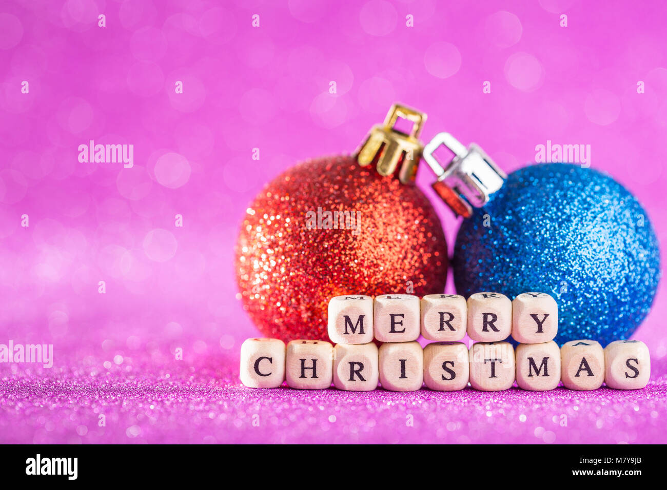 Christmas and New Year Background. Blue аnd Red Christmas Ball on Pink Holiday and New Year Abstract Blurred Defocused Background. For design or photo Stock Photo