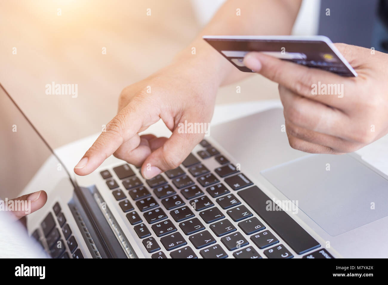 Close up woman hands holding credit card in front of laptop on the desk. Easy way online shopping concept Stock Photo