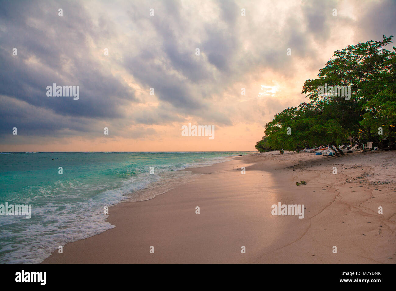 Deserted heavenly beach, with turquoise water and pink sky at sunset Stock Photo