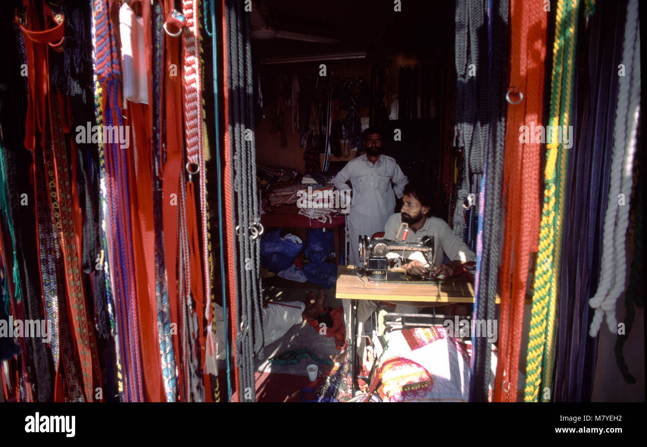 Dubai UAE Nadd Al Sheba Camel Supply Man Shops using Sewing Machine